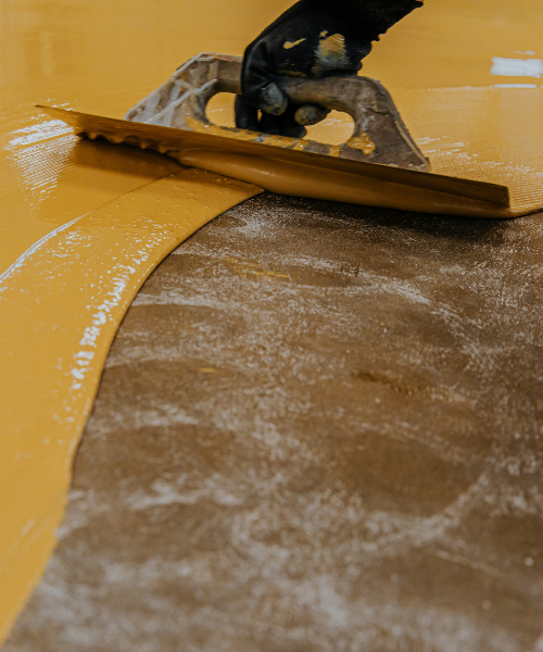 A person using a tool on a yellow surface