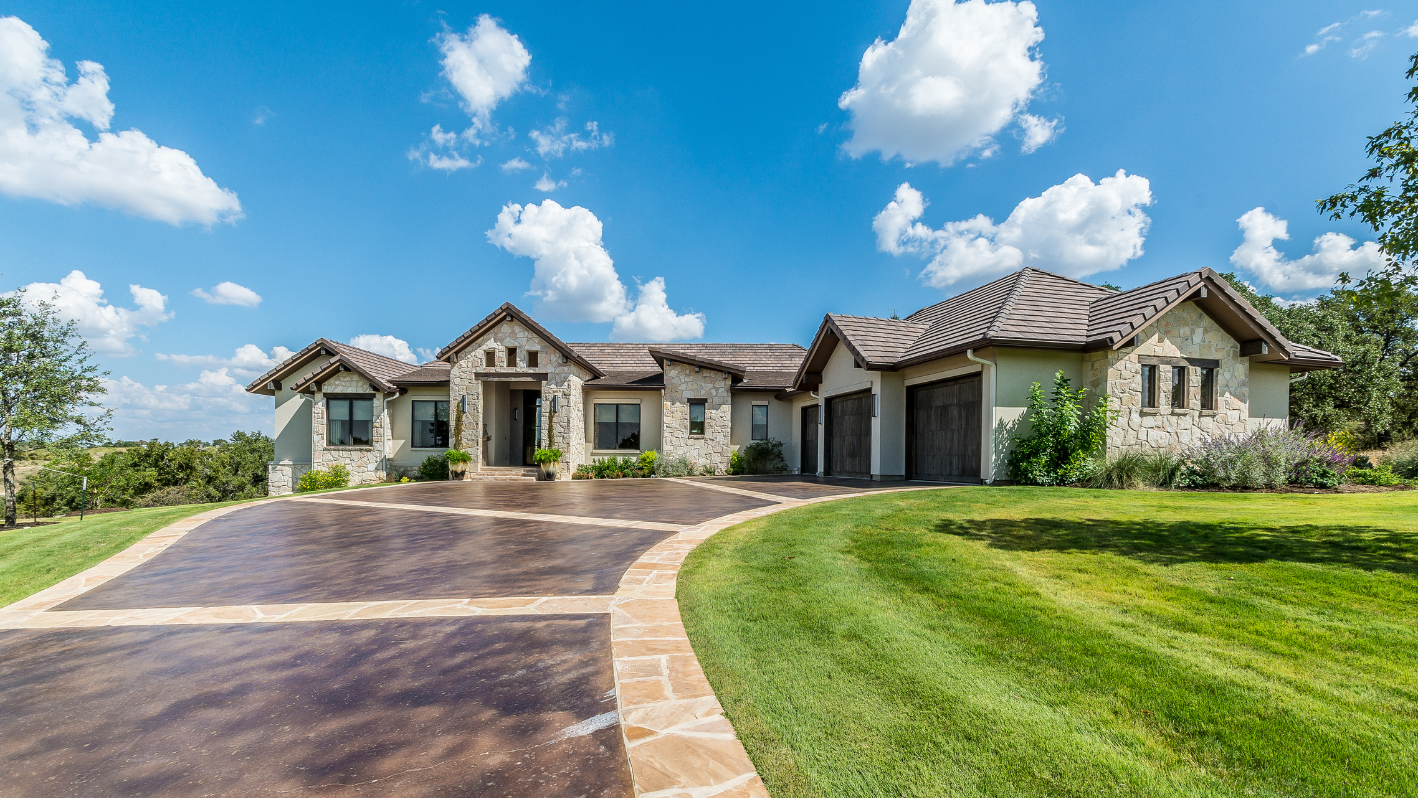 A large house with a driveway and grass